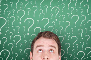 Chalkboard of question marks behind young man