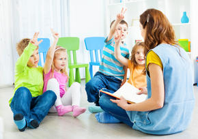 Kids sitting in a circle around their teacher