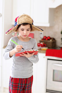 Boy wearing winter hat and writing