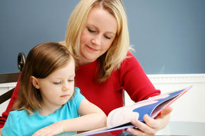 Teacher reading book with young student