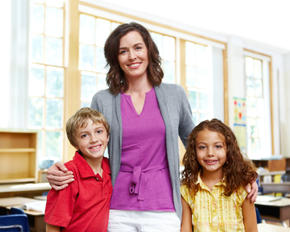 two students standing with a teacher