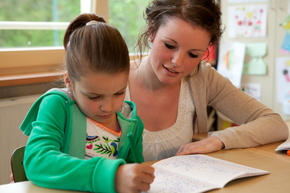 student and teacher working on a paper