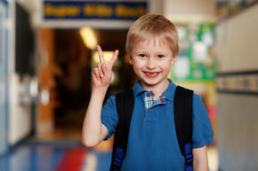 school boy holding up the peace sign